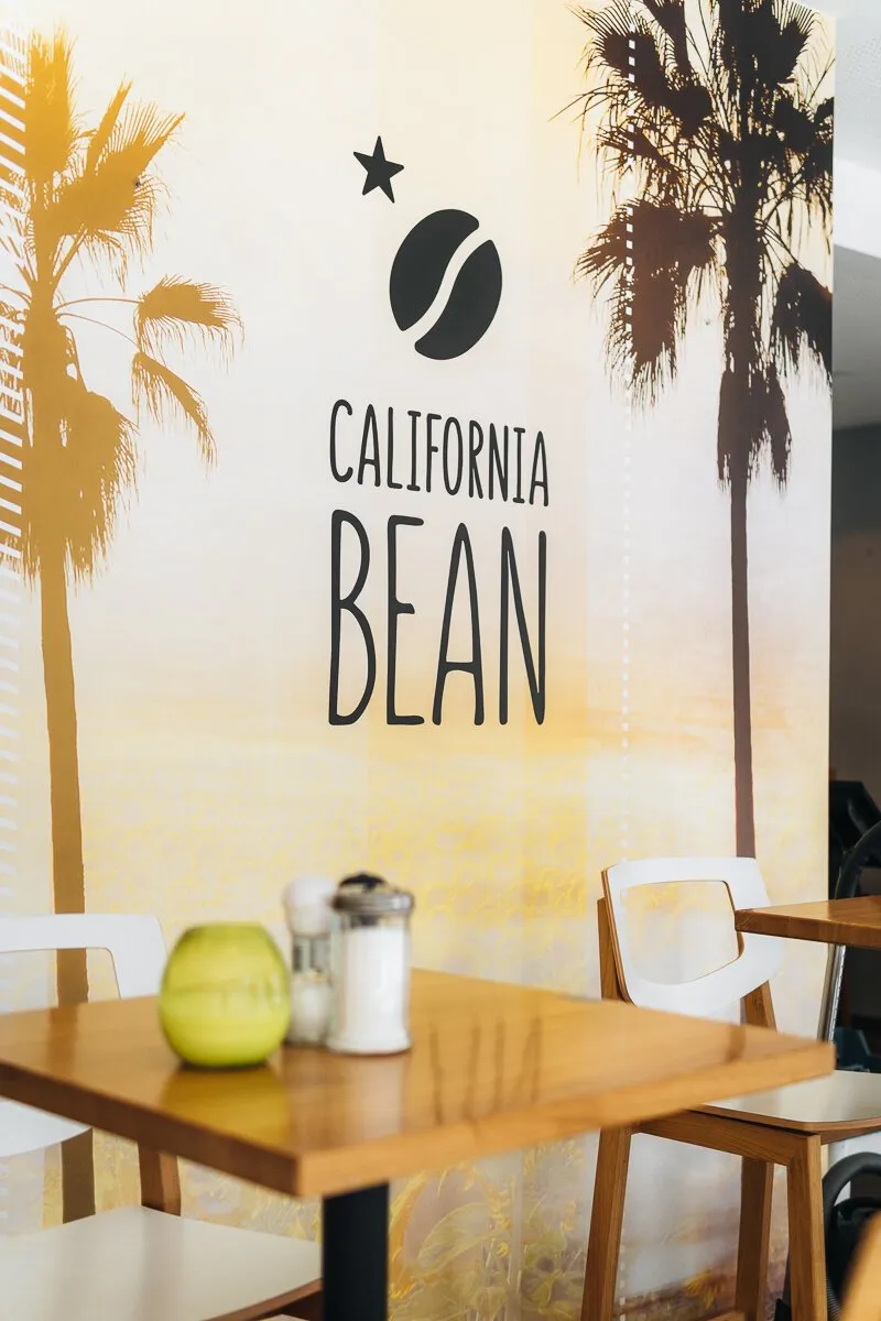Innenaufnahme im California Bean Café, 2er Platz vor Fototapete mit Logo