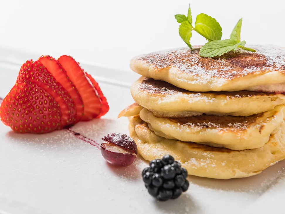 Pancakes with icing sugar and fresh fruits